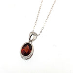 .60 Checkerboard cut Oval Garnet set in 14 karat white gold and hanging on 18" 14K Cable pendant chain.