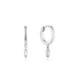 Add a touch of shimmer to your everyday wardrobe with these silver huggie hoops featuring a single cubic zirconia baguette, guaranteed to make you shine. The classic baguette jewelry just got a modern makeover with the Glow Getter collection. These statement pieces will let you shine in the spotlight and become timeless favorites.   • Material: rhodium plated on sterling silver • Earring length: 18mm • Weight: 1.5g